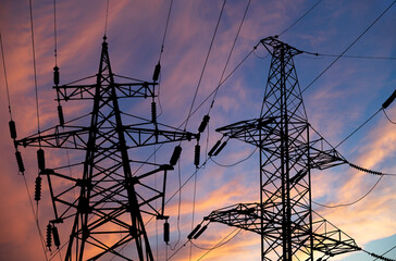 Electricity pylon (high voltage power line), black contour,  against the background of a romantic evening sky