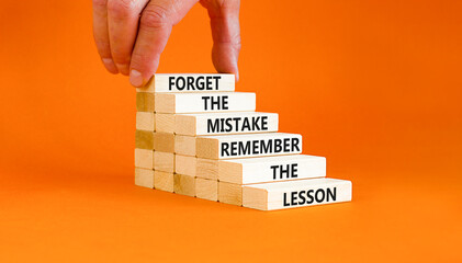 Wall Mural - Lesson from mistake symbol. Concept words Forget the mistake remember the lesson on wooden blocks on a beautiful orange table orange background. Businessman hand. Business lesson from mistake concept.