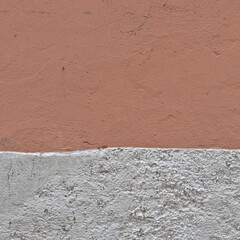 Italy, Perugia, summer 2022. Fragment of a wall consisting of two parts. With red plaster on top and white stone below