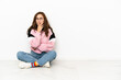 © luismolinero - Young caucasian woman sitting on the floor isolated on white background surprised and shocked while looking right