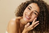 Fototapeta  - Woman beauty face close-up applying anti-aging moisturizer with fingers of her hand, skin health nails and hair, hair dryer style curly afro hair, body and beauty care concept