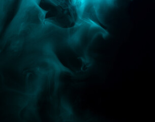 Wall Mural - Abstract background of chaotically mixing clouds of turquoise smoke on a background of darkness