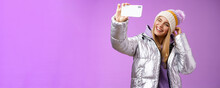 Joyful Carefree Charming Blond Girl Having Fun Wanna Post Pictures From Ski Resort Vacation Taking Seflie Holding Smartphone Mimicking Show Tongue Winking Look Mobile Display, Purple Background