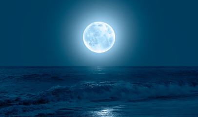 Poster - Night sky with blue moon in the clouds over the calm blue sea 