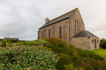 An old church in a green field in a gloomy weather