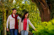 Indian couple wearing colourful warm sweater or woolen winter cloths and walking at garden