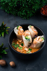 Wall Mural - Spring rolls with shrimps, cucumbers, rice and cashew nuts with sauce on a bowl.