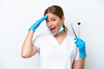 Dentist caucasian woman holding tools isolated on white background with surprise expression