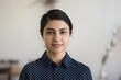 © fizkes - Positive beautiful young Indian woman in casual shirt looking at camera, smiling. Confident pretty 30s freelance businesswoman corporate head shot female business portrait
