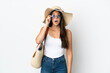 © luismolinero - Young Brazilian woman with Pamela holding a beach bag isolated on white background with glasses and surprised