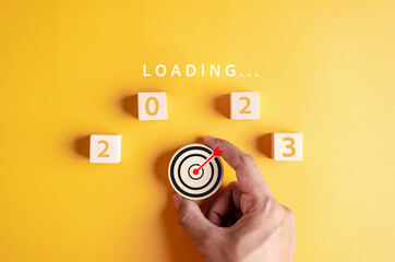 Poster - Target plan next year 2023 concept, Hand putting wooden cube block for loading progress from 2023 to countdown merry christmas and happy new year..