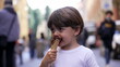 © Marco - Young boy eating ice cream cone outside. Child eats italian gelato outdoors during summer day