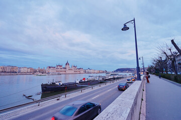 Wall Mural - River promenade in Budapest. Road on the shore with Parliament building on the background.