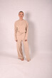 © Шамиль Алиев - A young girl in beige home clothes on a white background in the studio