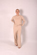 © Шамиль Алиев - A young girl in beige home clothes on a white background in the studio