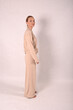 © Шамиль Алиев - A young girl in beige home clothes on a white background in the studio