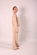 © Шамиль Алиев - A young girl in beige home clothes on a white background in the studio