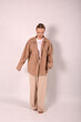 © Шамиль Алиев - A young girl in beige home clothes on a white background in the studio