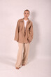 © Шамиль Алиев - A young girl in beige home clothes on a white background in the studio