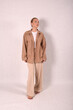 © Шамиль Алиев - A young girl in beige home clothes on a white background in the studio