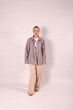 © Шамиль Алиев - A young girl in beige home clothes on a white background in the studio