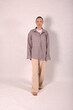 © Шамиль Алиев - A young girl in beige home clothes on a white background in the studio