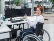 © Михаил Решетников - Caucasian woman in wheelchair showing thumb up while sitting in open space office.