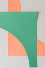 Wall Mural - pale green and orange paper shapes on blank paper