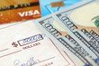 © lesslemon - bank check, cash money, debit and credit bank card on table, various types of payments, prepare writing a check, closeup
