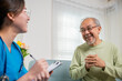 © sorapop - Elderly man takes doctor at home telling about health complaints, Asian young nurse writing prescription clipboard while talking during home visit sick senior old man, Healthcare and medical concept