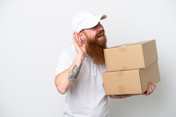 Wall Mural - Delivery reddish man isolated on white background listening to something by putting hand on the ear