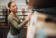 © Kay A/peopleimages.com - Student search bookshelf for books in library for education, knowledge and learning about history, philosophy and language study. Happy woman with book for reading, studying and project research