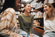 © K Abrahams/peopleimages.com - College friends, library and together to study while talking about book, research and knowledge from education and learning. University women happy during funny conversation while studying at school