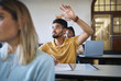 © K Abrahams/peopleimages.com - University student, hands and answer question in classroom for teaching, school education or learning. Young man, college student and raised hand for asking questions while studying in campus lecture