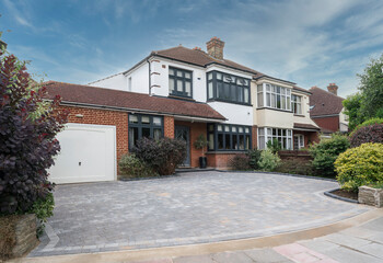 typical semi-detached house in south east england, uk with anthracite grey windows and block paving 