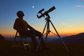 Wall Mural - man with astronomy telescope looking at the night sky, stars, planets, moon and shooting stars.