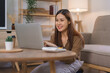 © snowing12 - Home office concept, Female freelance is sitting on floor to working and shopping online on laptop