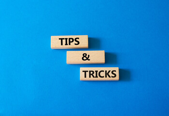 Wall Mural - Tips and tricks symbol. Wooden blocks with words Tips and tricks. Beautiful blue background. Business concept and Tips and tricks. Copy space.