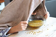 Kamillendampfbad - Hausmittel bei Erkältung und Husten - Frau inhaliert über einer Glasschüssel mit Kamillenblüten