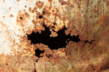 Old steel broken tank hole from rust close up.