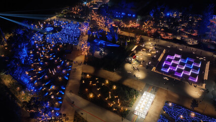 Aerial drone night distant shot from illuminated with Christmas lights futuristic Ellinikon Experience public Park an urban regeneration project and cultural center in Athens riviera, Attica, Greece