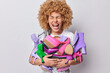 © wayhome.studio  - Emotional curly haired woman carries pile of various footwear sorts out her shoes at home being shopaholic and buys fashionable shoes on sale poses indoor against grey background has big collection