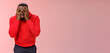 Shocked upset young african american bearded guy in red hoodie facepalm hide face hands peeking through fingers sad devastated lose hope, standing sad pink background grieving feel sorrow