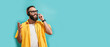 © San4ezz007 - Call center operator, online store service manager wears headphones speaks into microphone answers call, leads negotiations advises online sales. Isolated on blue background