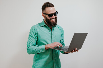 Portrait of smiling positive businessman standing with portable computer in hands. Laptop concept. Promotion poster. Programmer, web developer holding a laptop in his hands and looking at the camera