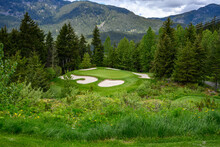 Golf Green Protected By Sand Traps On A Mountain Golf Course, Hole Surrounded By A Forest
