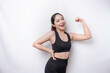 © Reezky - Excited Asian sporty woman wearing a sportswear showing strong gesture by lifting her arms and muscles smiling proudly
