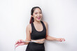 © Reezky - Portrait of cheerful young Asian woman in sportswear measuring waist with tape, feeling happy about losing weight at home. Healthy lifestyle, sports and slimming diet concept