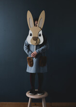 Little Child Standing On A Chair Holding A Bunny Rabbit Mask