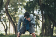 © Charnchai saeheng - a tired young man resting and breathing holding a bottle of drinking water and towel on the road in the park morning.